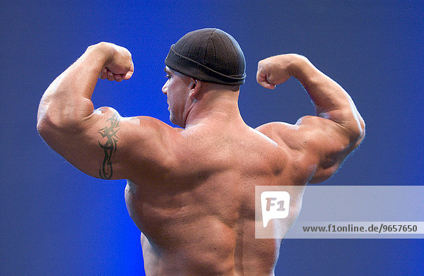 Bodybuilder zeigt seine Muskeln auf der Fitnessmesse FIBO in Essen