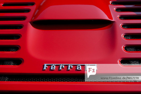 Ferrari Schriftzug auf der Motorhaube eines Sportwagens der italienischen Edelmarke im typischen rot