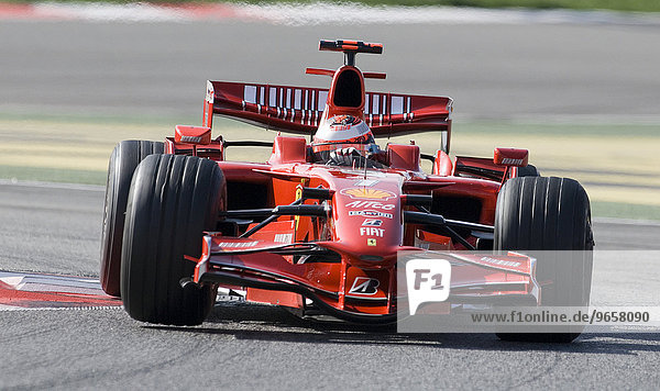 Driver Kimi Raeikkoenen in his Ferrari Formula 1 race car entering a corner on the Circuit de Catalunya race track in Barcelona  Spain  Europe