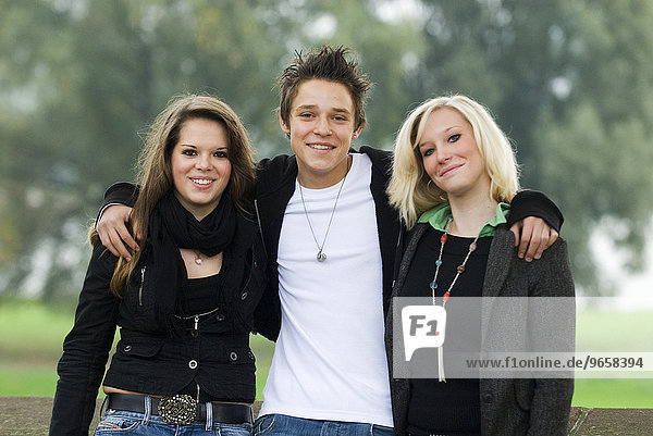 A 16-year-old boy flanked by two 16-year-old girls