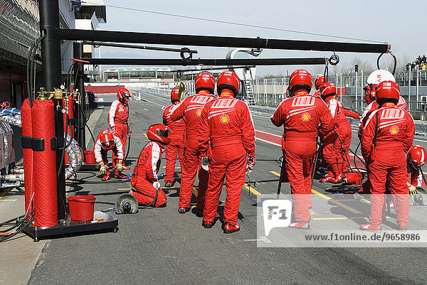 Ferrari mechanics getting ready for a pit stop in the box during Formula 1 test runs on the Circuit de Catalunya near Barcelona  Spain  Europe