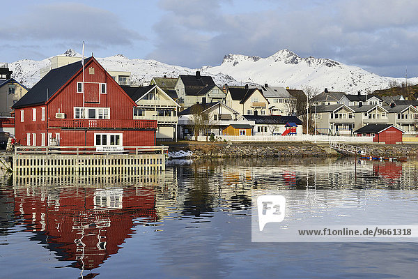 Rotes Haus mit Privatkai und mehrere Häuser des Ortes  vor weißen Bergen  Svolvær  Lofoten  Nordland  Norwegen  Europa