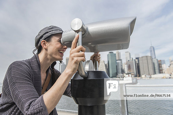 Woman watching through coin-operated binoculars