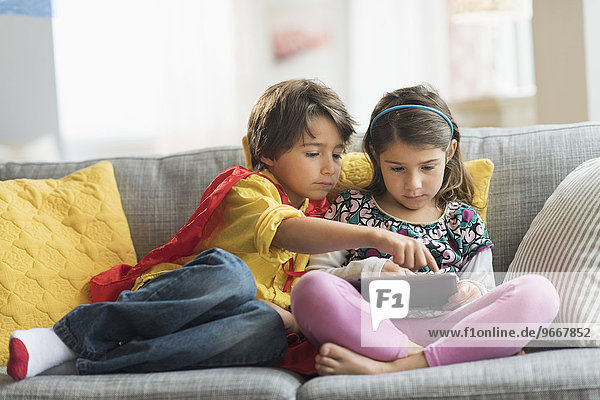 Children (6-7) playing game on tablet pc at home