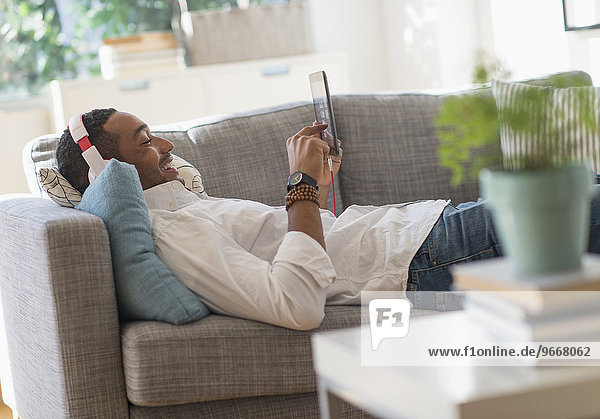 Man relaxing on sofa with tablet pc