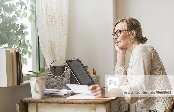 Woman sitting at desk and contemplating