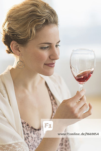 Young woman swirling glass of red wine