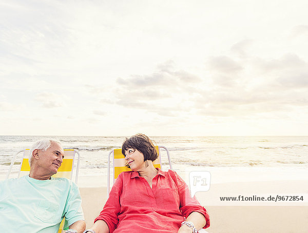 Older couple relaxing on beach