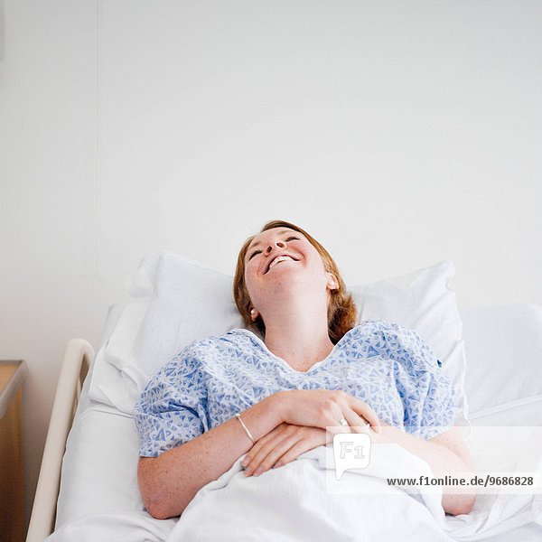 liegend liegen liegt liegendes liegender liegende daliegen Frau lachen Krankenhaus Bett Ansicht
