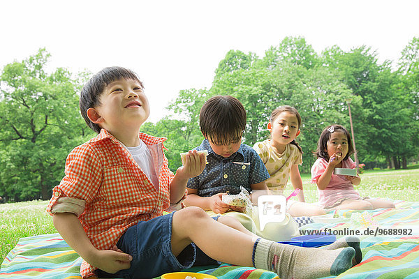 Japanese kids having picnic in a park