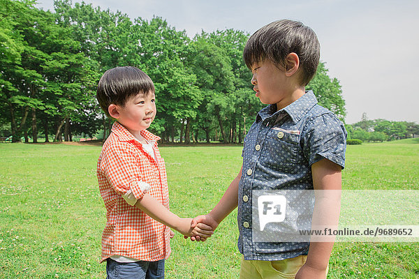 Japanese kid shaking hands in a park