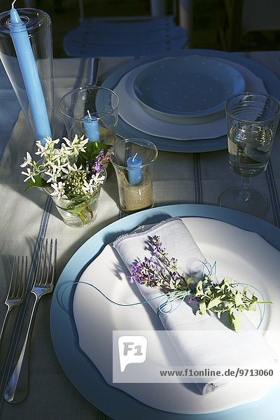 Gedeckter Tisch in Blau und Weiss mit Blumendekoration