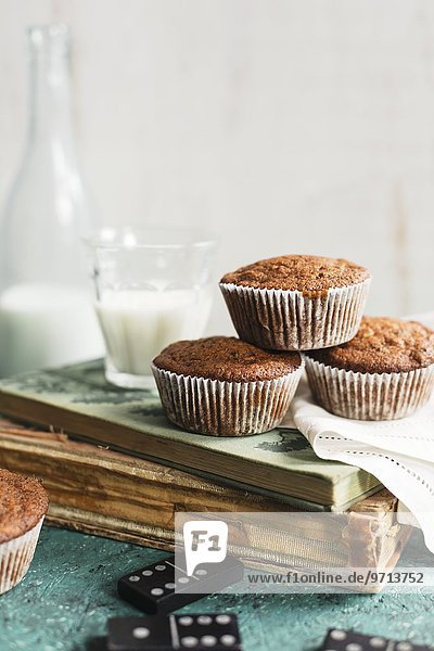 Muffins und Milch auf altem Buch