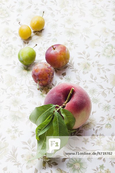 Reneclauden  Mirabellen und ein weisser Pfirsich mit Blatt