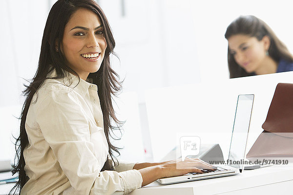 Geschäftsfrau Notebook lächeln Büro tippen