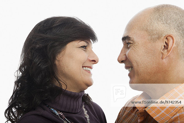 Hispanic couple smiling at one another