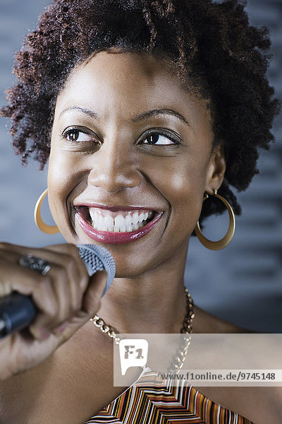 African American woman singing karaoke in nightclub