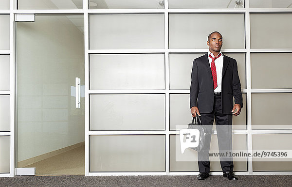 Mixed race businessman standing in modern office