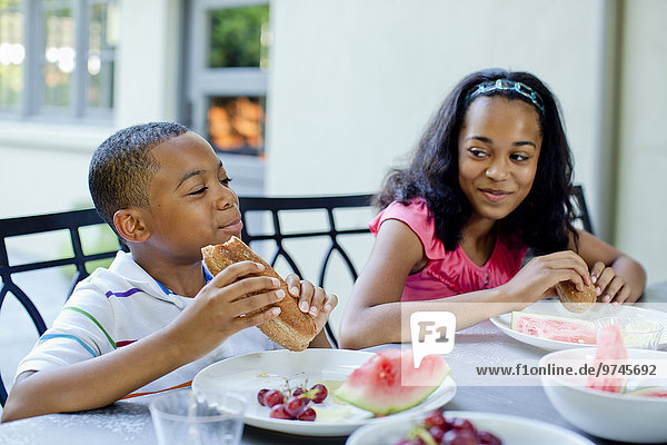 African American children eating lunch outdoors