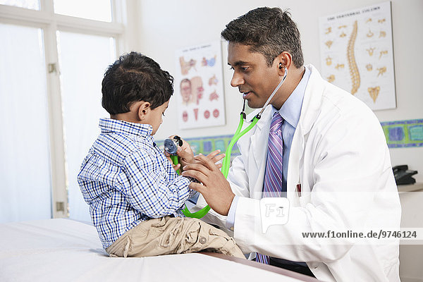 Indian doctor examining boy in doctor's office
