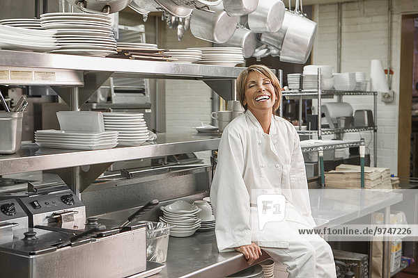 Caucasian chef sitting in commercial kitchen