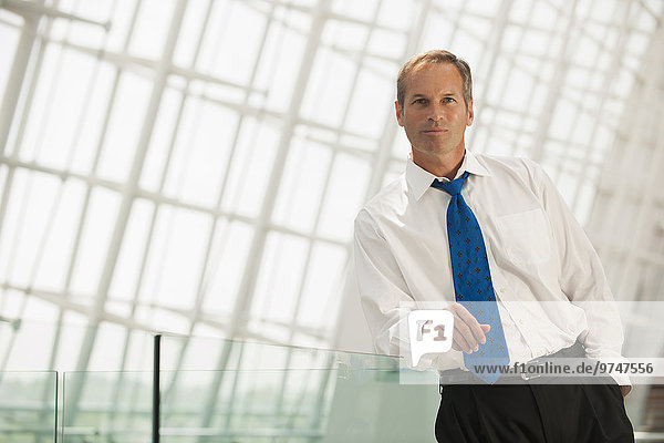 Caucasian businessman leaning on railing