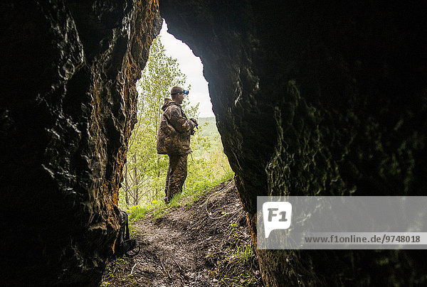 Felsbrocken Außenaufnahme stehend Europäer Mann Anordnung Höhle