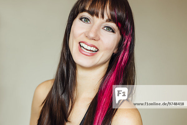 Smiling Caucasian woman with pink dye in hair
