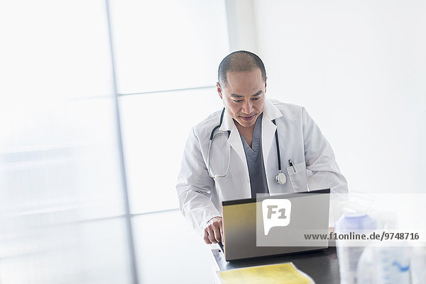 Korean doctor using laptop in office