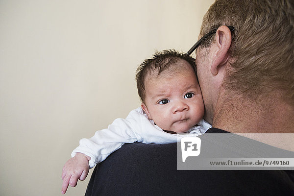 Close up of father holding mixed race baby
