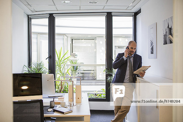 Caucasian businessman talking on cell phone in office