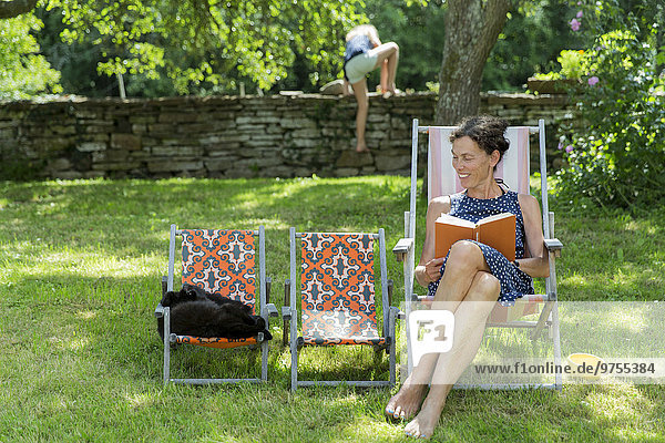 Woman reading book on sun chair