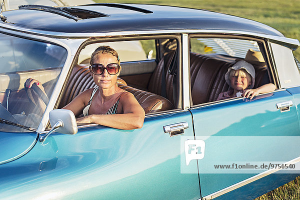 Woman with daughter in vintage car