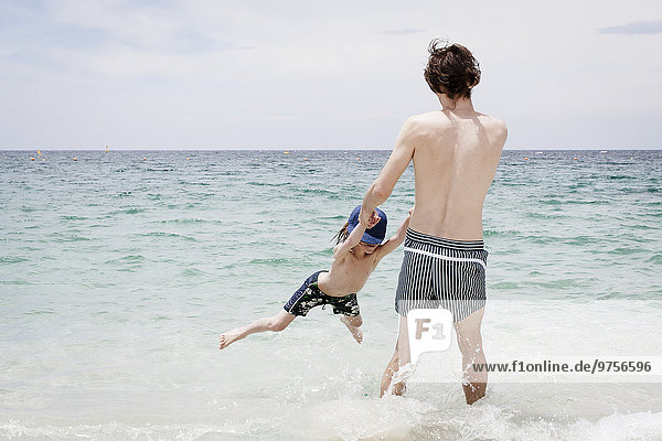 Father playing with son on beach