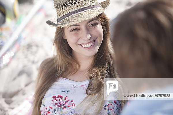 Lächelnde junge Frau schaut den Mann am Strand an.