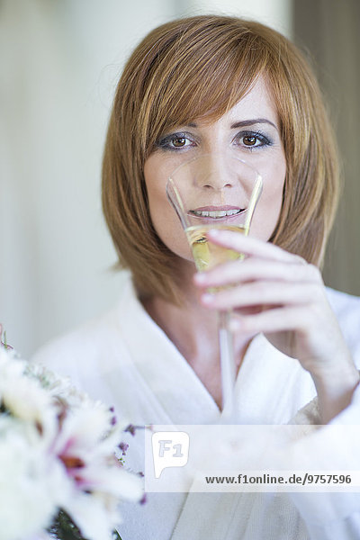 Portrait of young woman drinking glass of champagne
