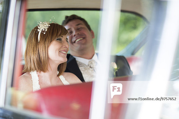 Glückliche Braut und Bräutigam im Auto