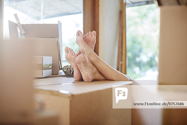 Couple moving house  feet on a box