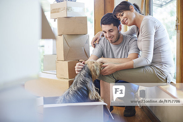 Couple moving house sharing a moment with the dog