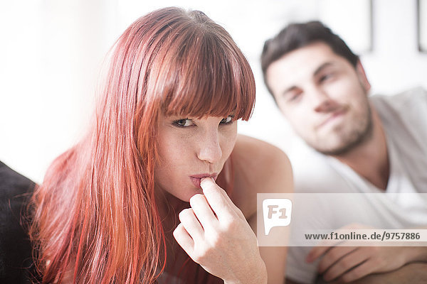 Portrait of young woman licking fingers