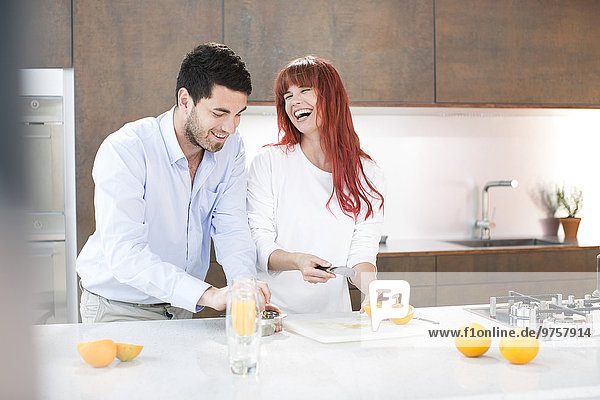 Paar in der Küche macht frischen Orangensaft