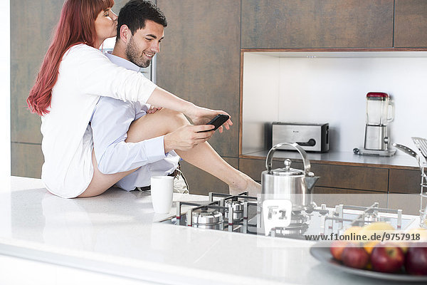 Couple in kitchen sharing an intimate moment