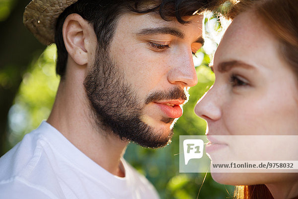 Ein junges Paar teilt sich einen intimen Moment im Freien.