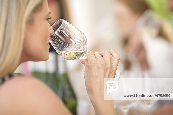 Woman smelling white wine on a wine tasting session