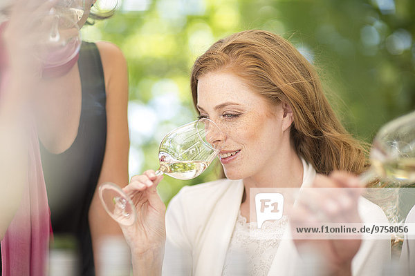 Frau riecht Weißwein bei einer Weinprobe