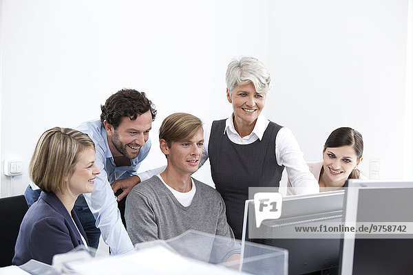 Smiling business team working on computer in office