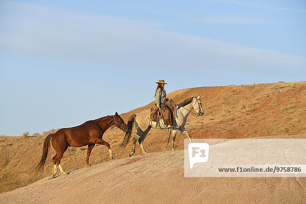 USA  Wyoming  Cowgirl mit zwei Pferden in Badlands
