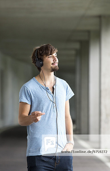 Junger Mann hört Musik mit Kopfhörern