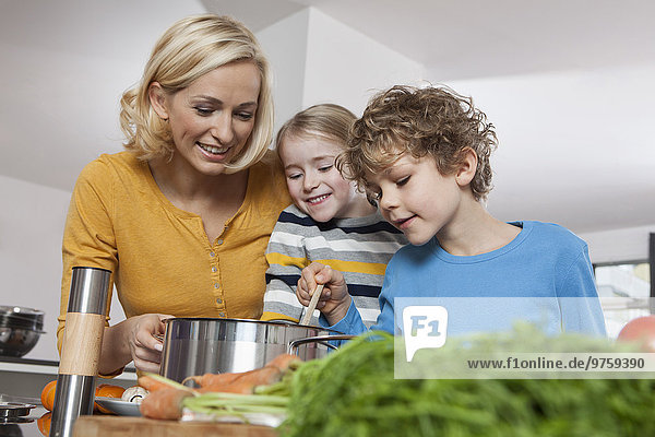 Mutter  Tochter und Sohn kochen in der Küche