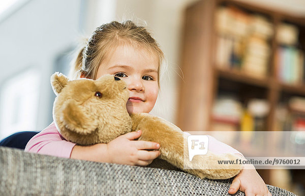 Porträt eines lächelnden Mädchens mit Teddybär